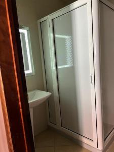 een badkamer met een glazen douche en een wastafel bij دار الضيافة Dar Diafa Essalam in Agadir