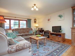 a living room with a couch and a tv at Coachmans Lodge - Uk35952 in South Pool