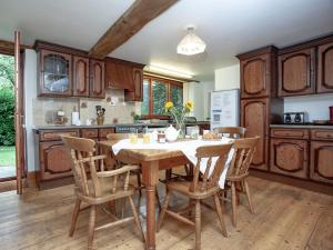 a kitchen with a wooden table and chairs at Coachmans Lodge - Uk35952 in South Pool