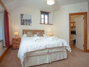 a bedroom with a large bed with white sheets at Coachmans Lodge - Uk35952 in South Pool