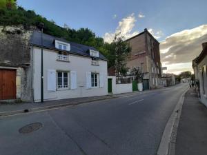 eine leere Straße mit einem weißen Gebäude am Straßenrand in der Unterkunft l'atypique des fouleries in Châteaudun