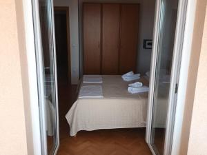 a small room with a bed with towels on it at Apartments Villa Katarina in Makarska +97 photos