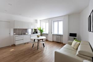 a white living room with a couch and a table at Casa Amelia in Domodossola