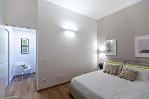 a white bedroom with a bed and a table at Casa Amelia in Domodossola