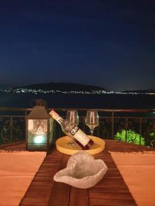 a table with a bottle of wine and a glass at Sea view luxury apartment in Aiándion