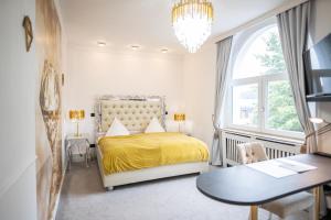 a bedroom with a bed with a yellow bedspread and a table at VILLA BOWDY in Niederzier