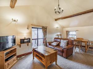 a living room with a couch and a tv at The Granary in Poulton le Fylde