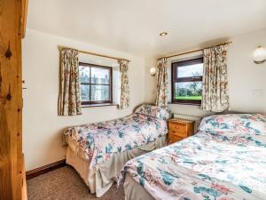 a bedroom with two beds and two windows at The Granary in Poulton le Fylde