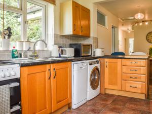 a kitchen with a sink and a washing machine at The Horseshoe Annex in Steyning