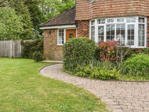 a brick house with a walkway in front of a yard at The Horseshoe Annex in Steyning