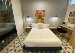 a hotel room with a large bed and a desk at Aut&eacute;ntico Vertical Playa del Carmen in Playa del Carmen