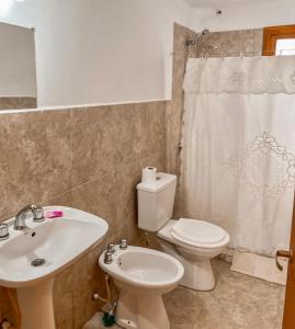 La salle de bains est pourvue de toilettes blanches et d'un lavabo. dans l'établissement Diente de León, à Trevelín