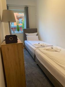 two beds in a room with a lamp and a window at Viadrina Rooms & Apartments Frankfurt-Oder am Park im Zentrum in Frankfurt Oder