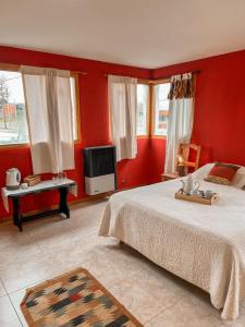 1 dormitorio con paredes rojas, 1 cama y TV en Diente de León en Trevelín