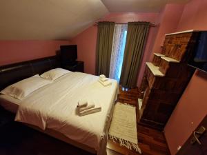 1 dormitorio con 1 cama con 2 toallas en Cabana Casuta de Ciocolata, en Teşila