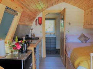 una pequeña cocina con una cama en una casa pequeña en Burnbank Glamping Pod, en Acharacle