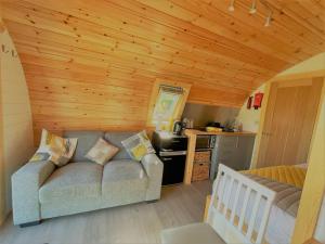 a living room with a couch and a kitchen at Burnbank Glamping Pod in Acharacle