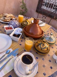 a table with a tea pot and a cup of coffee at Auberge Kasbah Des Dunes in Merzouga