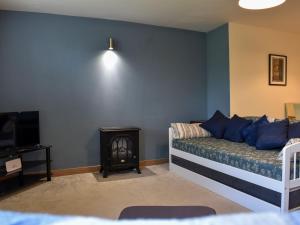 a bedroom with a bed and a television and a table at Red Gable Cottage in Shap