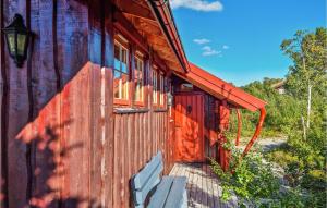 eine rote Tür an der Seite eines Holzgebäudes in der Unterkunft Cozy Home In Hovden I Setesdalen With Kitchen in Hovden