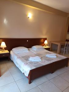 a bedroom with a large bed with two tables and two lamps at Arianna in Paleokastritsa