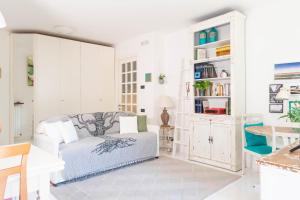 a white living room with a couch and shelves at La Casa di Mila in Fermo