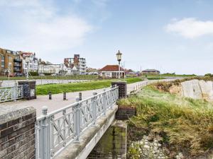 a bridge over a beach with buildings in the background at Sea Breeze in Cliftonville