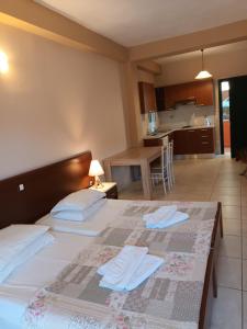 a bedroom with a large bed and a kitchen at Arianna in Paleokastritsa
