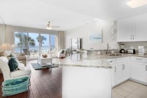 a kitchen and living room with a view of the ocean at Sterling Sands 111 in Destin