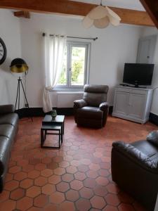 a living room with a couch and chairs and a television at Chez kathie in Arrest