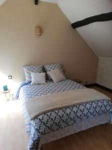 a bedroom with a bed with a blue and white comforter at Chez kathie in Arrest