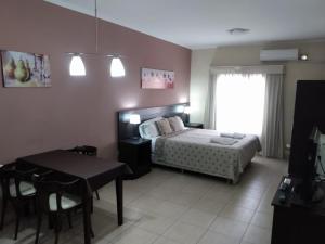 um quarto com uma cama, uma mesa e uma sala de jantar em Antares Apartments em Campana