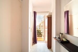 a hallway with a door to a balcony with purple curtains at Hostal Bonanza in Sitges