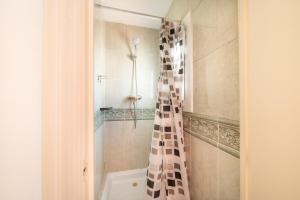 a bathroom with a shower with a black and white shower curtain at Hostal Bonanza in Sitges