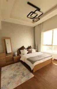 a bedroom with a large bed and a window at Sharjah Rose Tower in Sharjah