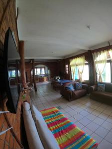 ein Wohnzimmer mit einem Sofa und einem TV in der Unterkunft Casa Praia da Gamboa in Garopaba