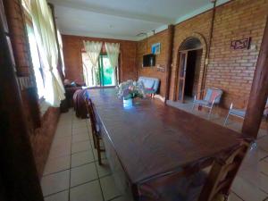 a dining room with a large wooden table and chairs at Casa Praia da Gamboa in Garopaba