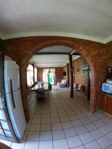 a kitchen with a brick wall and a refrigerator at Casa Praia da Gamboa in Garopaba