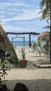 聖貝爾納多德爾比恩托的住宿－älanacasadeplaya，海滩上设有椅子和凉亭,还有大海