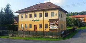 une maison jaune sur le côté d'une rue dans l'établissement Apartmán BON, à Horní Bečva