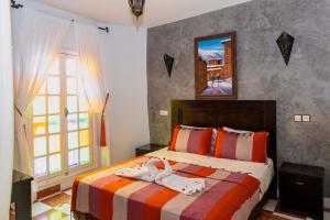 a bedroom with a bed with towels on it at Hotel Cap Sim in Essaouira