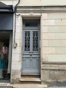 a blue door on a building with a window at L'Arlequin- studio tout confort- Coeur de ville in Chinon
