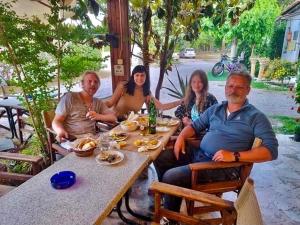 un grupo de personas sentadas en una mesa en XeniCamp-Retreat, en Nauplia