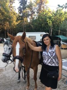 una mujer parada junto a un caballo blanco y marrón en XeniCamp-Retreat, en Nauplia