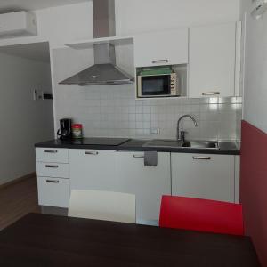 cocina blanca con fregadero y microondas en Villa Treccani Apartments en Malcesine