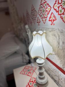 a white lamp sitting on a table next to a bed at B&B 091 in Palermo