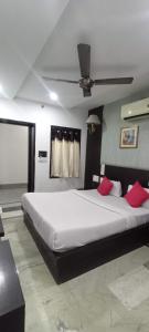 ein Schlafzimmer mit einem großen weißen Bett mit roten Kissen in der Unterkunft Hotel Laxman Resort by The Golden Taj Group &Hotels in Agra