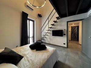 - une chambre avec un lit et une télévision murale dans l'établissement Sant'Andrea - Luxury Rooms in Vucciria, à Palerme