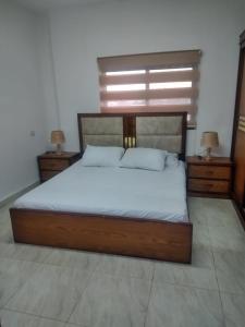 a bedroom with a large bed with two night stands at Furnished apartment for rent in jarash شقة مفروشة للإيجار في جرش in Jerash