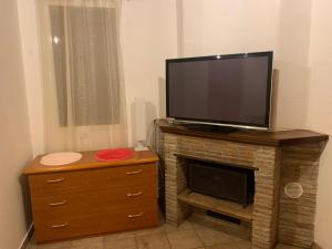 TV de pantalla plana con chimenea en Casa nel verde Orbetello, en Albinia